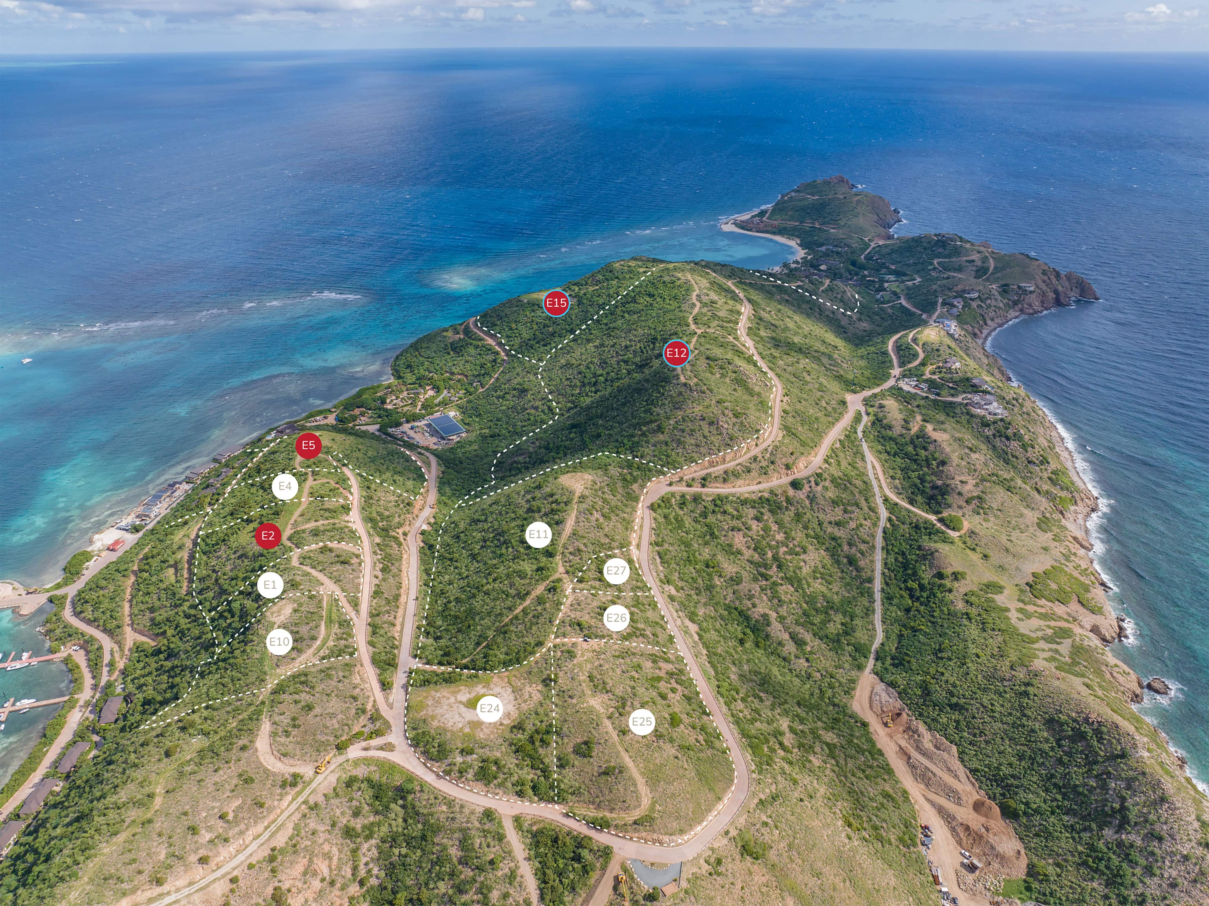 Aerial view of a coastal landscape with a winding road network on a hilly peninsula extending into the ocean. Property lots are marked with circles and labels along the road. Surrounding waters are vivid shades of blue and green, and the terrain is lush with vegetation.