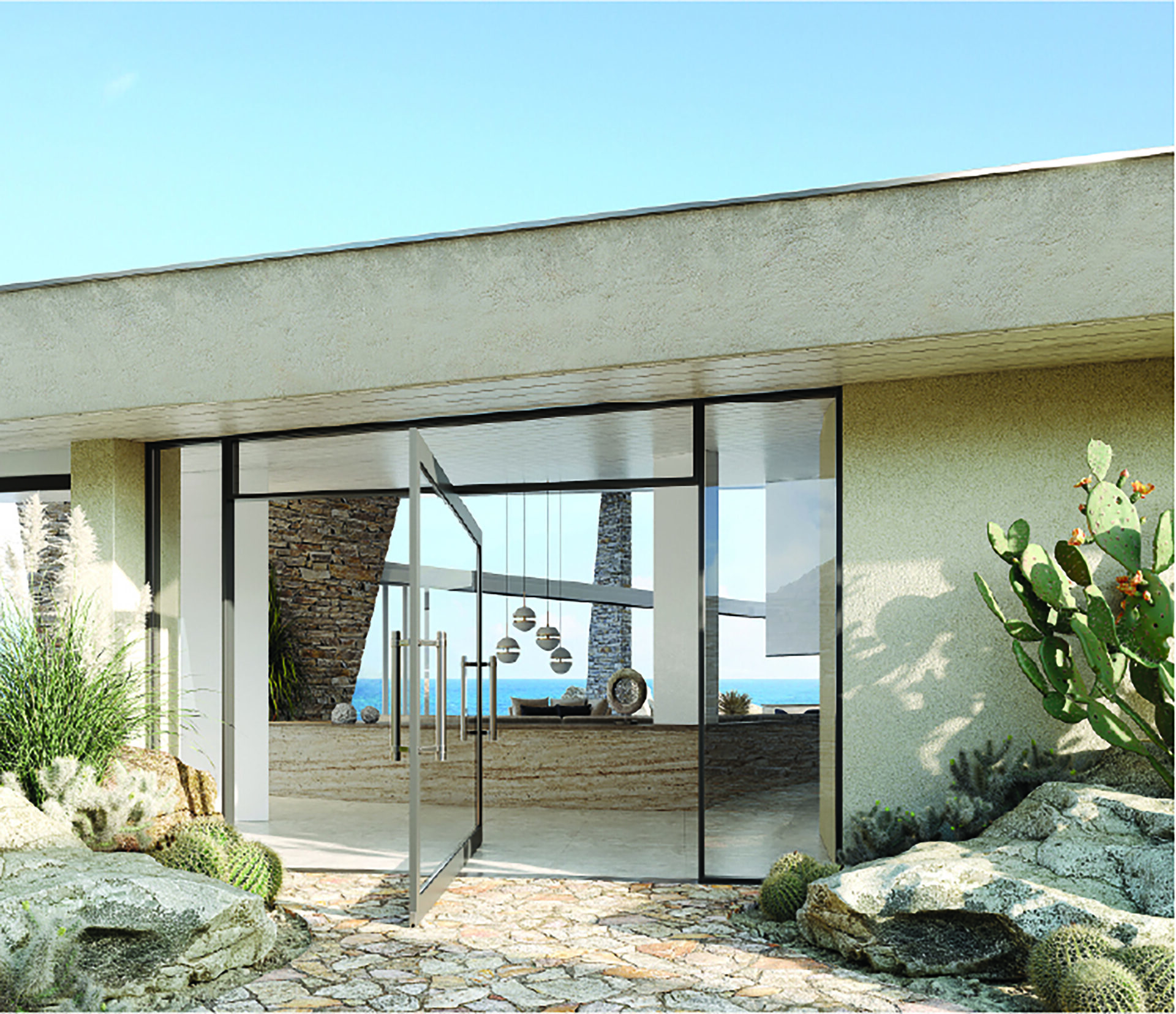 A modern building with large glass doors and windows reflects a clear blue sky at this boulder-accented homesite. The entrance is adorned with desert landscaping, showcasing rocks, cacti, and succulents. Inside, a glimpse of a stylish interior with hanging lights and stone walls awaits.