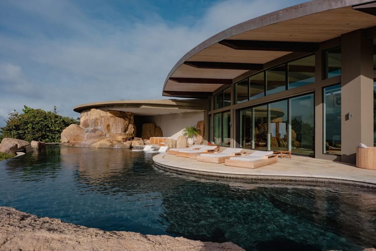 Halo Villa's organic cliffside architecture featuring a living green roof and custom boulder waterfall.
