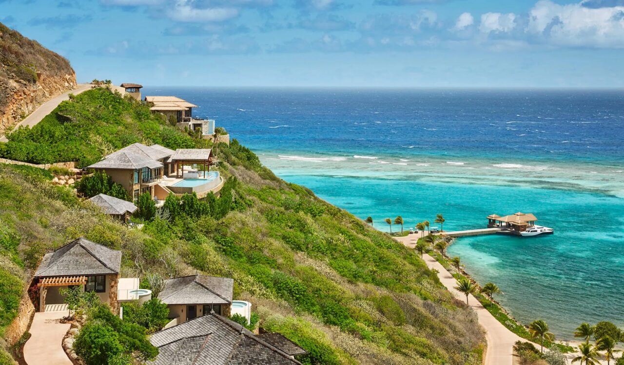Luxury cliffside villas overlooking turquoise waters and private boat dock at Oil Nut Bay, Virgin Gorda.