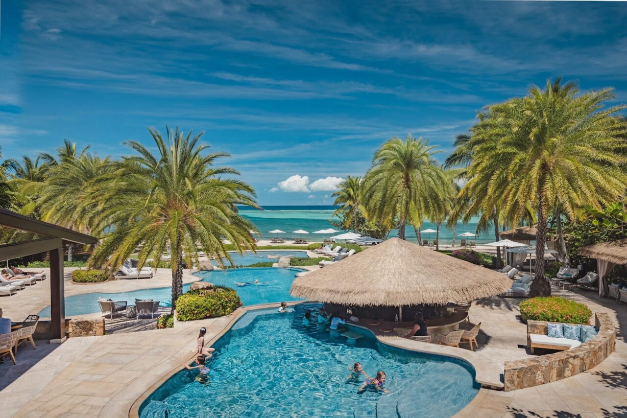Guests swimming and relaxing at the oceanfront Beach Club pool bar at Oil Nut Bay, Virgin Gorda.